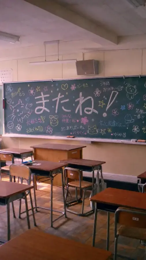かわいい寄せ書きと大きな「またね！」の文字が残された学校の黒板と教室の写真