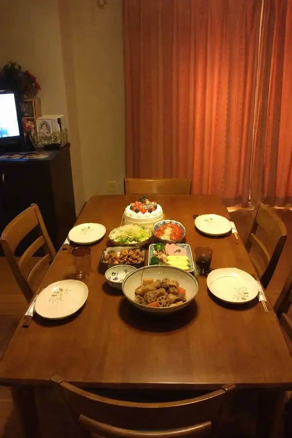 家族4人分の料理と食器が並んだ食卓を撮影した写真