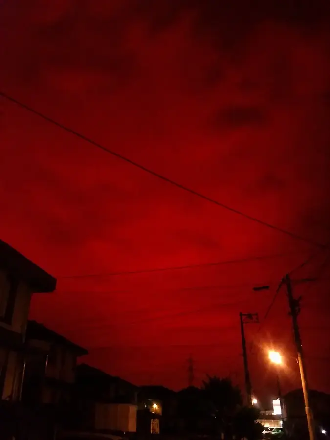 濃い赤色の空に覆われた夜の住宅街